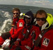 3 surfeurs à bord de Gwalaz, trimaran éco-conçu